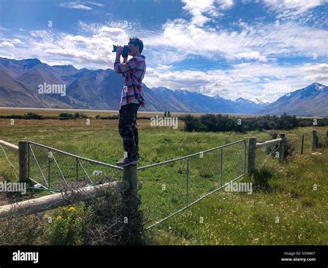 Photographer on a fence Stock Photo - Alamy