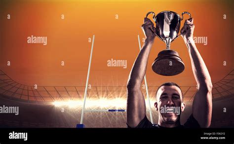 Composite Image Of Portrait Of Successful Rugby Player Holding Trophy