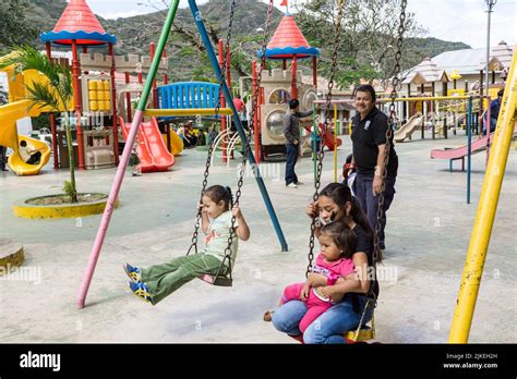 El padre empuja a un niño en un columpio mientras que otros niños