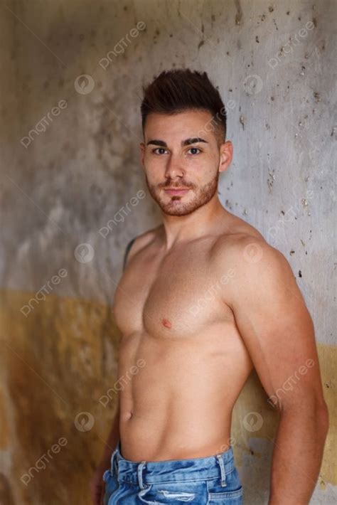 Attractive Guy Showing His Muscles In A Old House Background And