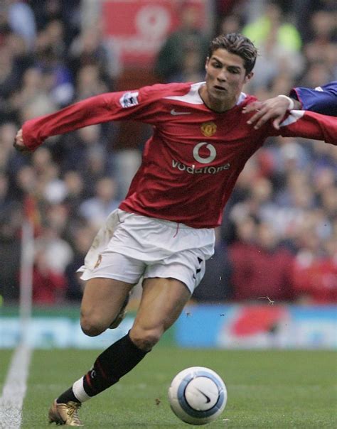 Two Men Playing Soccer On A Field With Spectators In The Stands