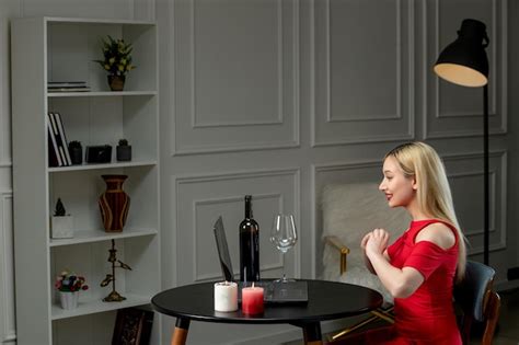 Amour virtuel jolie fille blonde en robe rouge à distance avec du vin et des bougies excitées