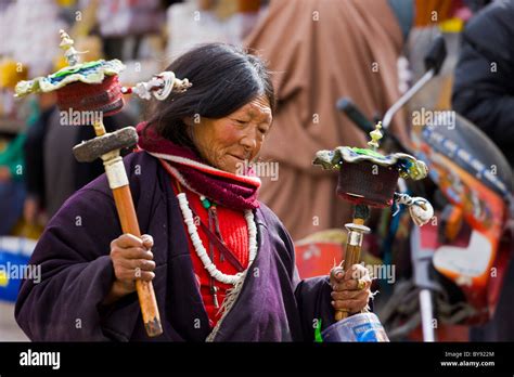 Tibetan Woman Pilgrim Spinning Two Prayer Wheels In The Barkhor Lhasa