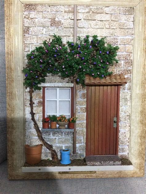 A Miniature House With Potted Plants In Front Of It And A Door On The