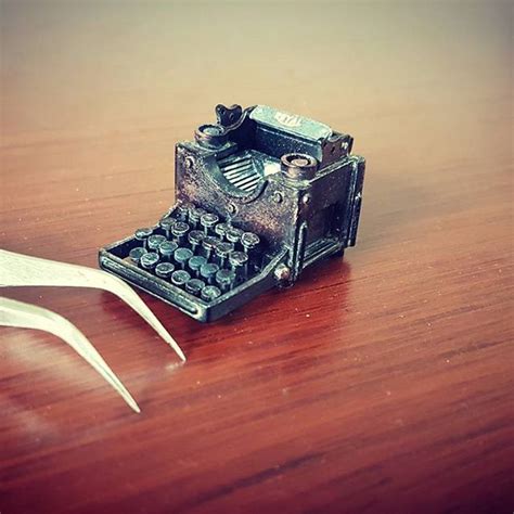 An Old Fashioned Typewriter Sitting On Top Of A Wooden Table Next To A