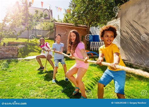 Group Of Kids Play Pulling Rope Game On The Lawn Stock Photo Image Of