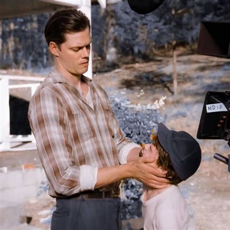 a man and woman standing next to each other in front of a camera on the ...