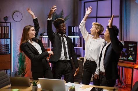 Felizes parceiros de negócios multirraciais em pé perto da mesa no