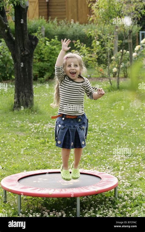 Petite Fille Blonde Sautant Sur Un Trampoline Banque De Photographies