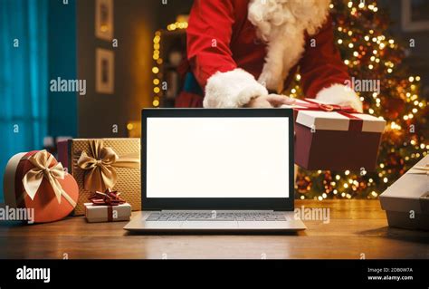 Santa Claus Bringing A Gift At Home On Christmas Eve And Blank Laptop