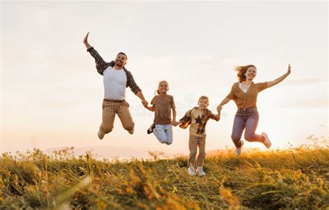 Familia Feliz Padre Madre Hijos Hijo E Hija Saltando Al Atardecer