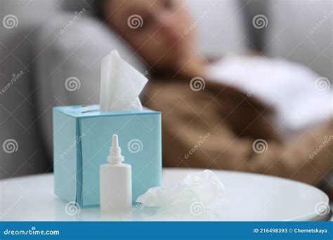 Ill Woman At Home Focus On Nasal Spray And Box Of Tissues Stock Image