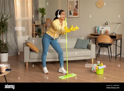 Housekeeping In Fun Excited Black Woman Singing Song Washing Floor In