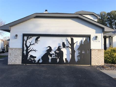 a garage with a painting on the side of it that has people and dogs in ...