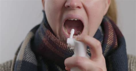 A Woman With A Sore Throat Sprays Medicine Aerosol Spray Down Her