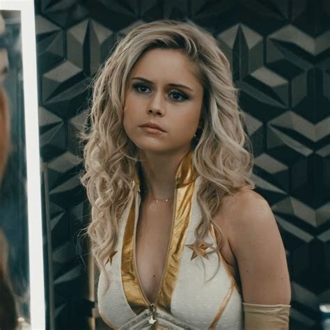 a woman with long blonde hair is looking at herself in the mirror and wearing gold jewelry