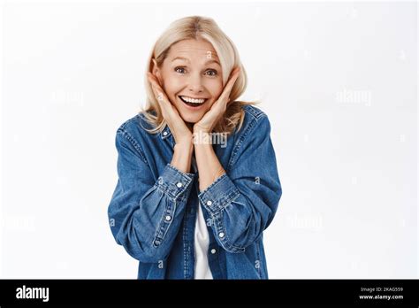 Une femme blonde excitée qui a l air surprise qui agite et qui regarde fasciné exprime la joie