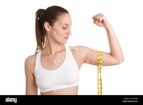 Powerful woman measuring her biceps with a yellow measuring tape Stock ...