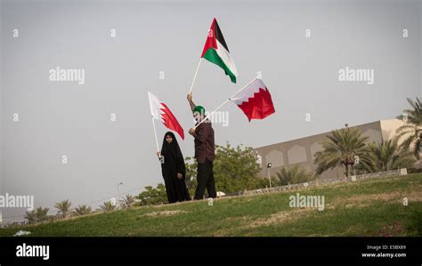 Bahraini Man With His Daughter Carrying The Flags Of Bahrain And