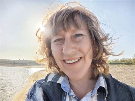 Blonde Woman Enjoys A Sunny Day By The Water During A Travel Adventure And Shares Her Experience
