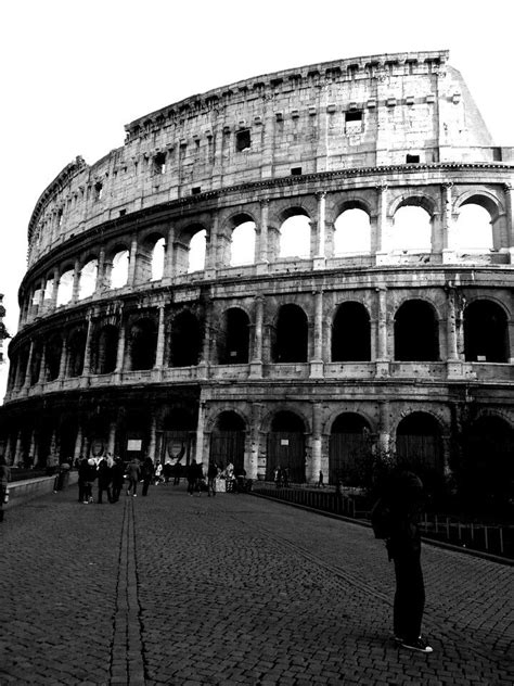 A Black And White Photo Of The Colossion In Rome With People Walking Around