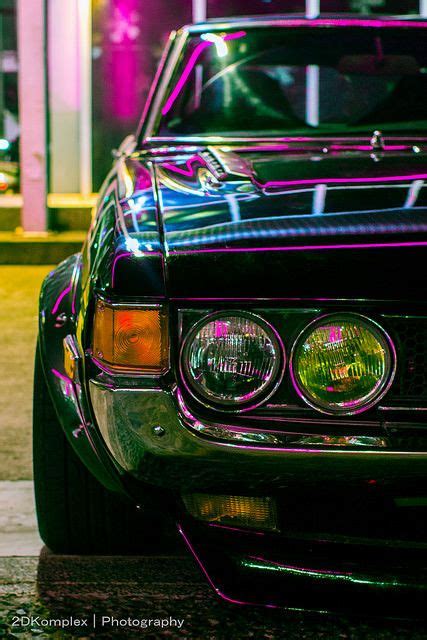 The Front End Of A Black Car With Purple Lights On It