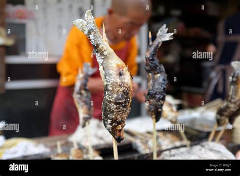 A street stall in Japan selling "ayu", in English known as sweetfish ...