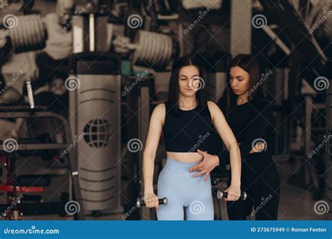 Female Personal Trainer Corrects And Advises Her Brunette Client During