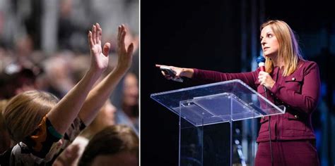 a woman standing at a podium with her hands up