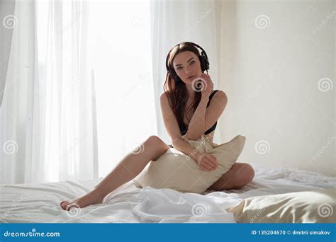 Beautiful Woman In Underwear Listening To Music With Headphones In The