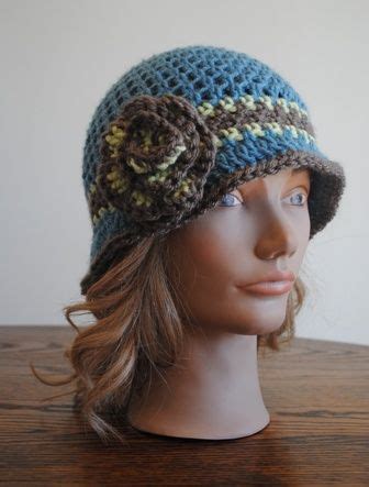 A Mannequin Head Wearing A Crocheted Hat With Flowers On The Brim