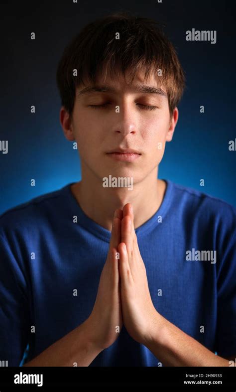 Young Man Praying In The Dark Room Stock Photo Alamy