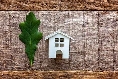 Premium Photo Toy House And Green Oak Leaf On Wooden Background