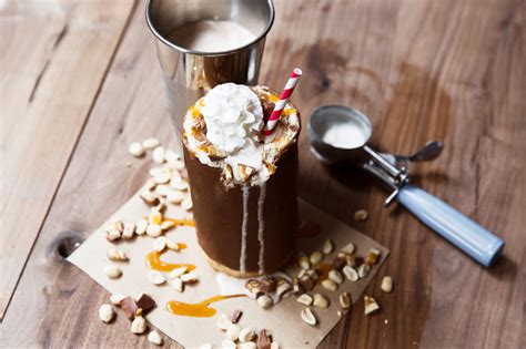 A candy bar milkshake in a cup made of homemade Snickers - Thrillist Recipes