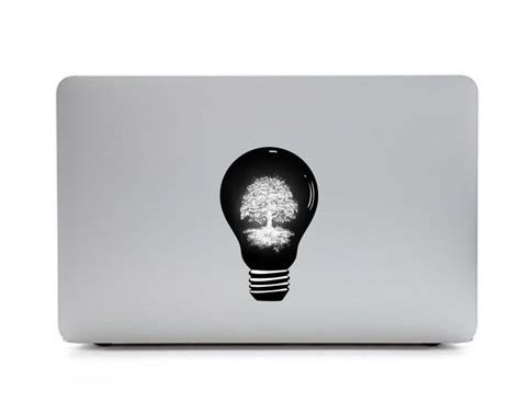 an open laptop with a tree in the light bulb sticker on it's cover