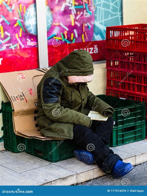 Homeless Man Reading Public Newspaper On The Stair Of The Walkway