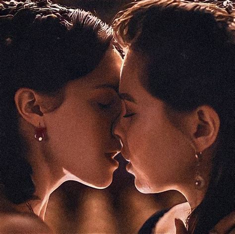 Two Women Are Kissing Each Other In Front Of A Mirror With Their Faces