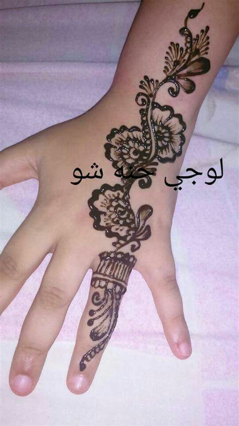 a person's hand with a henna on it and the words in arabic