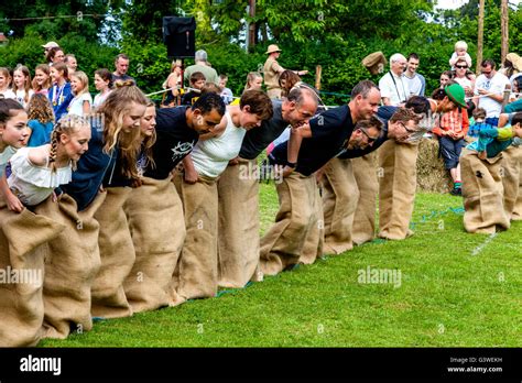 Teenagers And Adults Race In A Traditional Sack Race At The Medieval