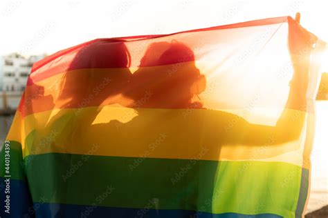 A Lesbian Couple Kissing Behind A Pride Flag Stock Photo Adobe Stock