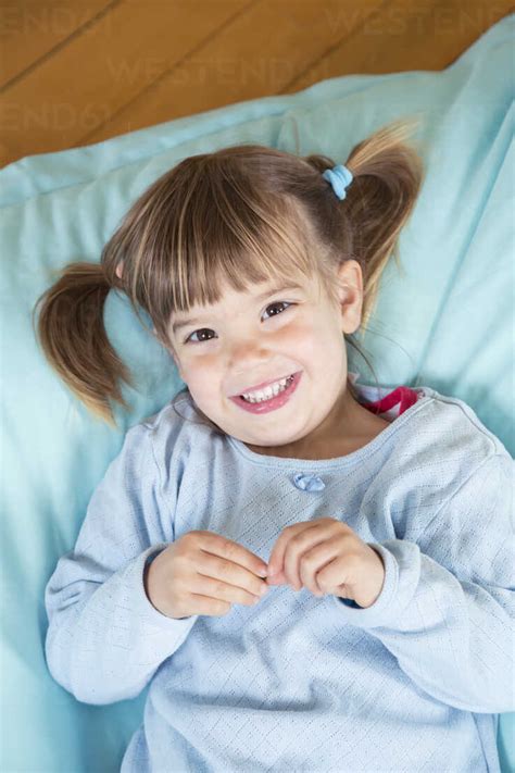 Portrait Of Smiling Little Girl Lying On Bean Bag Elevated View Stock