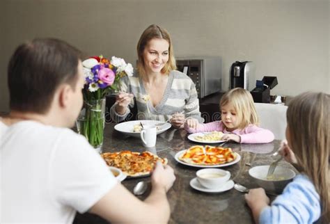 Familia Que Disfruta De La Comida Alrededor De La Tabla En Casa Imagen