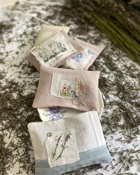 Four Embroidered Napkins Are Laying On The Ground With Lavender Flowers