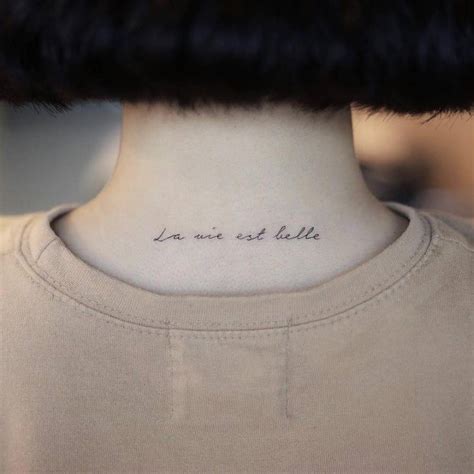 La Vie Est Belle Lettering Tattoo On The Upper Back