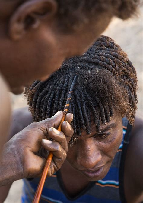 Afar man having a traditional hairstyle with a stick to make curly hair ...