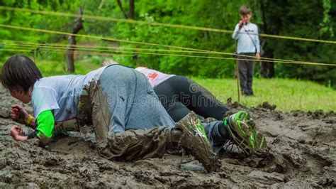 People Crawling Through Mud As Part Of Obstacle Course Stock Footage