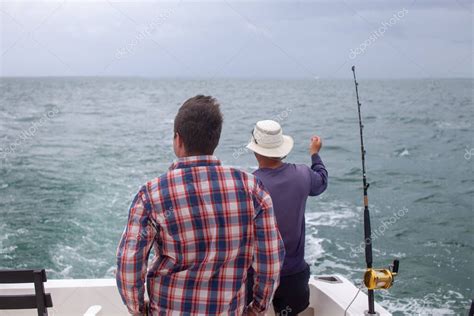 Un hombre comprueba sus cañas de pescar en un barco de alquiler en