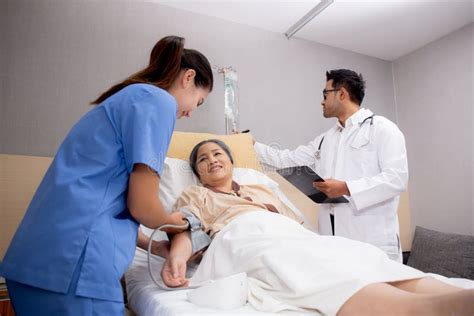 Doctor Checkup And Diagnostic While Nurse Measuring Blood Pressure With