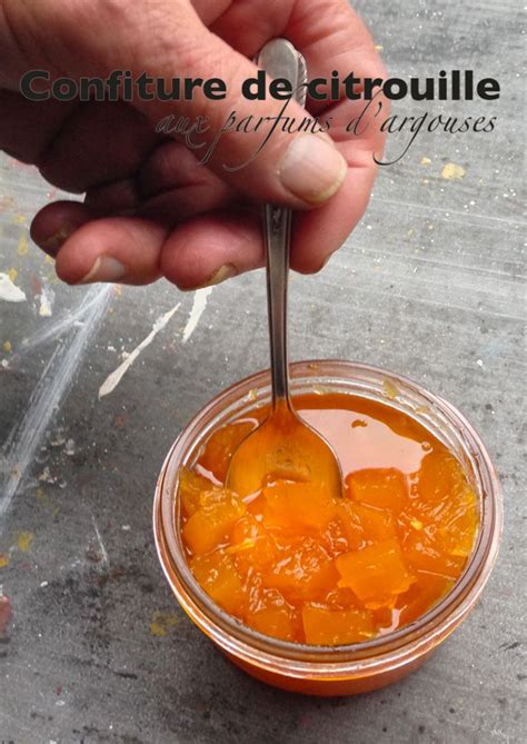 A Person Holding A Spoon In A Jar Filled With Oranges And Liquid On The