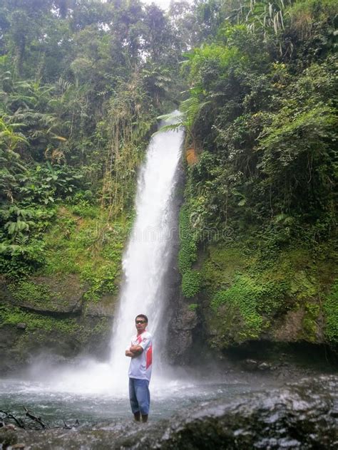 a man standing in front of a waterfall